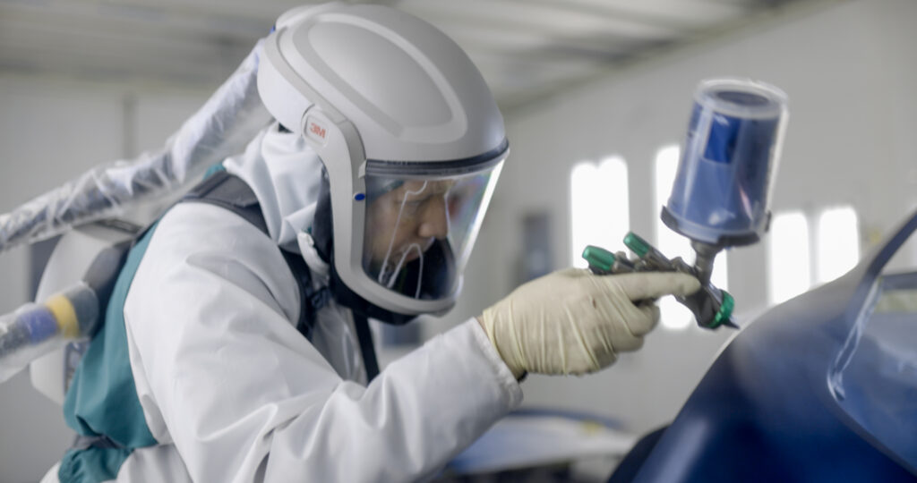 Painter in protective gear spraying blue car – Zamora’s Auto Body Collision repair services – Rockville auto body Painter in protective gear spraying blue car - Zamora's Auto Body Collision repair services - Rockville auto body