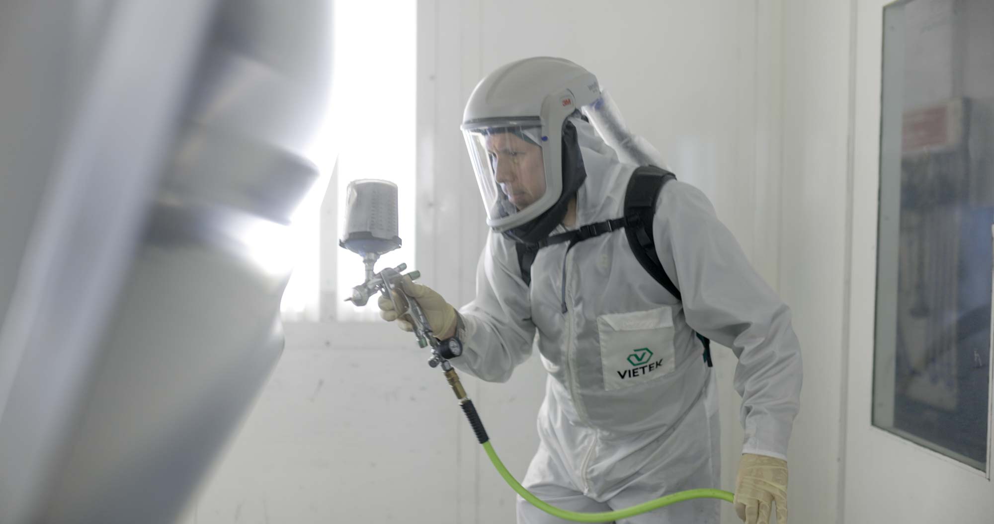 Zamora’s Auto Body Rockville MD-11 Auto paint repair technician spraying a vehicle panel in a paint booth