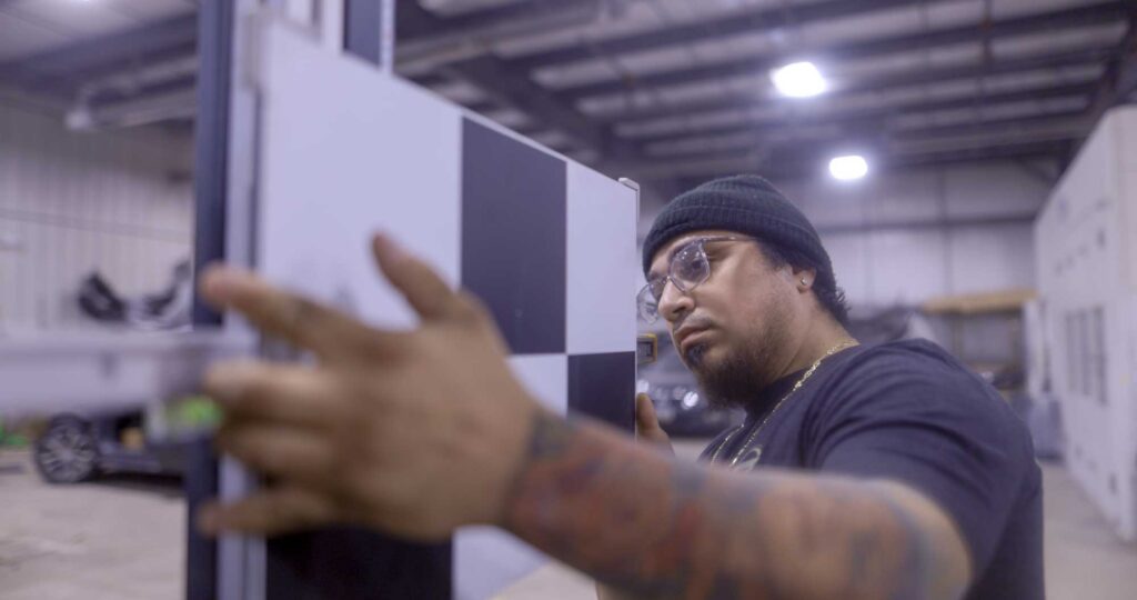 Zamora’s Auto Body Frederick MD-66 Collision repair technician comparing a vehicle paint color sample